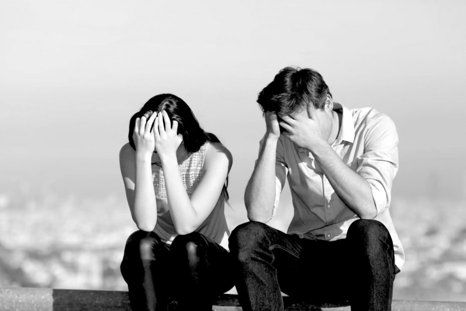 Trauriges Paar sitzt nebeneinander